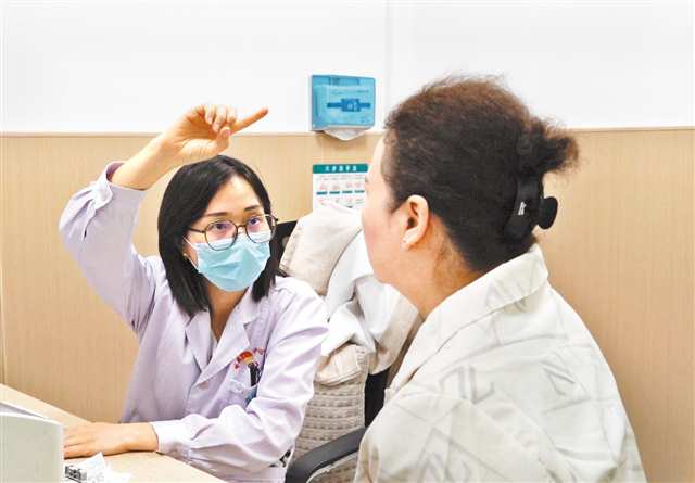 袁靳闲（左）为患者检查身体情况。